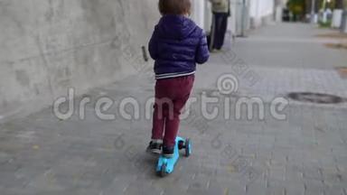 儿童骑滑板车在绿色踢脚板。